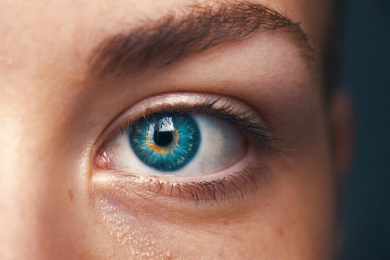 An older adult having an eye exam with a vision chart and diagnostic equipment in a doctor's office.