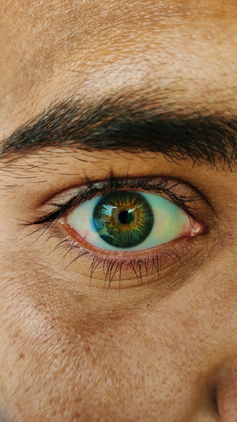 A middle-aged man using prescribed eye drops at home with a clean, organized table nearby.